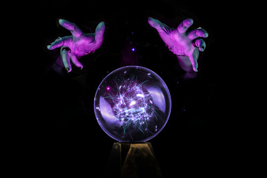 Fortune teller hands casting a spell over a crystal ball for divination, foresight, Halloween ritual in the darkness of the night