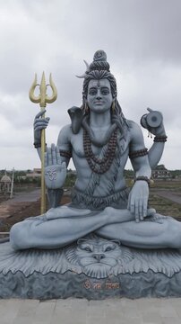 lord shiva statue drone view, hindu god shiva murti aerial shot, trishul holding shiva idol, religious temple shiva sculpture stock video.