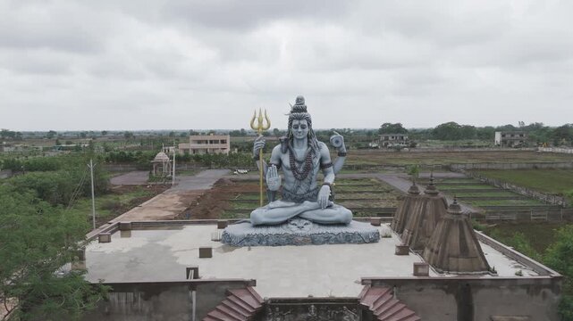 lord shiva statue drone view, hindu god shiva murti aerial shot, trishul holding shiva idol, religious temple shiva sculpture stock video.