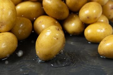 Whole fresh unpeeled potatoes in a splash of water.
