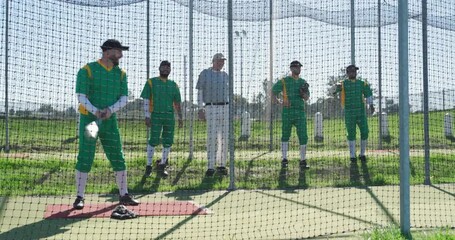 On coach nodding, right-handed batter is swinging bat in cage improving swing, copy space