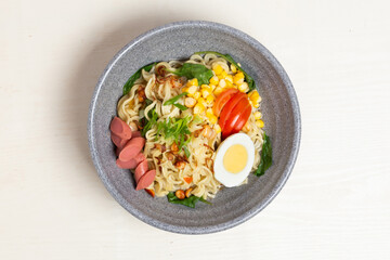 A warm bowl of Indomie Kuah, a popular Indonesian instant noodle soup. This image highlights the rich chicken broth, savory noodles, and fresh vegetables.
