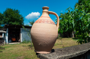 Clay water jug. Clay jug handmade isolated. Old ceramic pot. Traditional pitcher on a wooden...