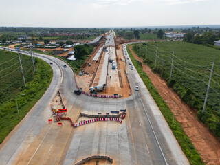 Drone shot of highway and overpass construction site with vehicles and road in a rural place