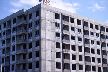 Fototapeta premium Construction site of modern residential building with crane in background