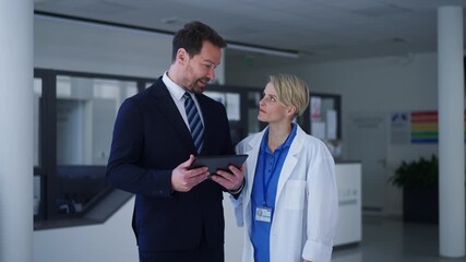Pharmaceutical sales representative introducing new medication to female doctor.