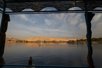 View from Elephantine island to the west early in the morning, with a boat in the river Nile, Egypt