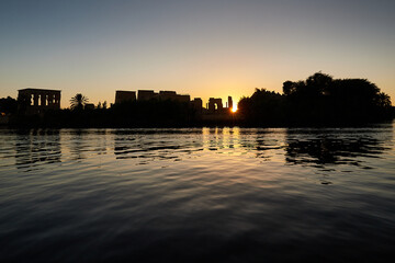 The silhouette of the temples on the island of Philae seen from the Low Aswan Dam at sunset