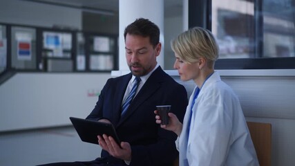 Pharmaceutical sales representative introducing new medication to female doctor.