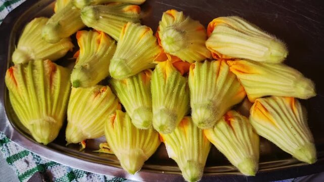 Close-up of fresh zucchini blossoms arranged neatly, ready for traditional Mediterranean cooking