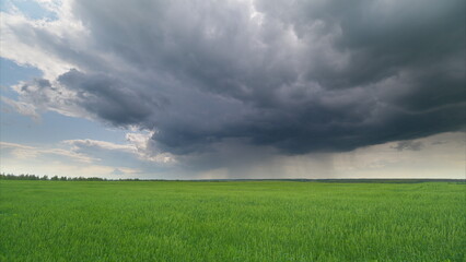 Dramatic and Intense Storm Clouds Floating Above the Vibrant Lush Green Fields in Nature