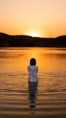 Bathed in sunset glow, she becomes the lake’s reflection of grace and allure