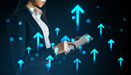 Businesswoman using digital tablet with glowing upward arrows representing success, growth, and innovation on a dark background.