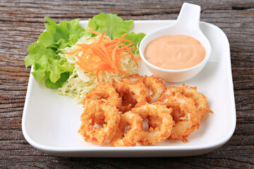 Breaded calamari with tartar sauce decorated on a black plate, Calamari with Herbal Tartar Sauce