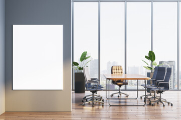 Modern corporate boardroom interior with conference table and blank vertical poster frame on wall, overlooking bright city skyline view. 3D Rendering
