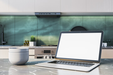 Modern kitchen interior with laptop on marble counter and blank screen for cooking website or recipe mockup template design concept. 3D Rendering