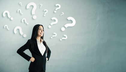 Confident businesswoman standing with hands on hips surrounded by floating white question marks on light background, symbolizing decision making.