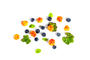 Ripe fresh blueberries and cloudberries with leaves isolated on white.
