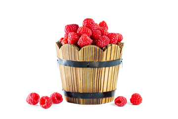 Ripe shiny raspberries in a wooden tub isolated on a white background.