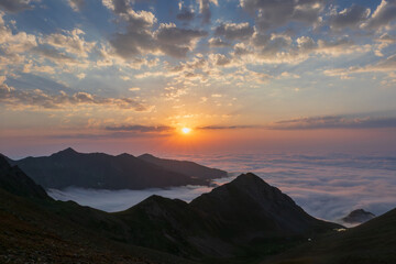 Sunset, high mountains, sea of clouds