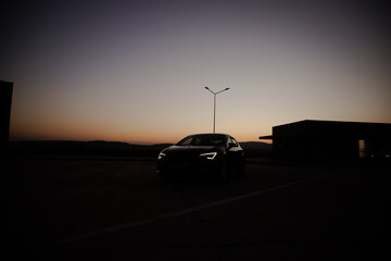 A modern black sport car in the sunset