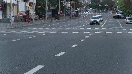 Kyiv, Ukraine - October, 2023. Timelapse. Cars moving on a for lane road while people crossing...