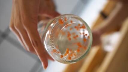 Woman filling glass jar with red lentils - Powered by Adobe