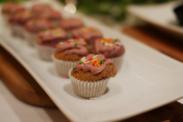 Mini Cupcakes with Pink Frosting and Sprinkles on a White Platter