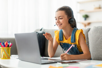 Online Remote Learning. Happy kid using computer having video chat discussing topic with teacher and class group. Teenager studying from home. Homeschooling during quarantine and coronavirus outbreak