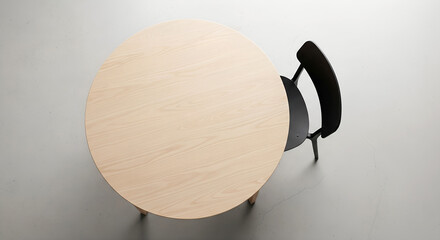 Round wooden table and black chair indoors, top view