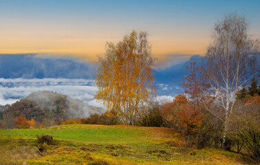 Obraz premium the sun rises high in the mountains with the colors of autumn