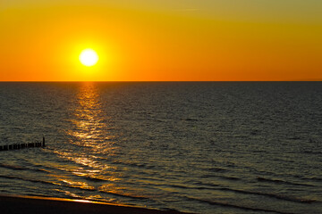 The sun sets over the Baltic Sea as seen from the town of the Mielno in Poland