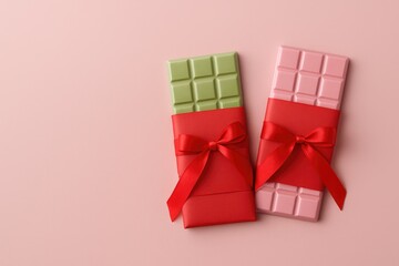 Seasonal gift ideas: pink and green chocolate bars in red wrapping on a pink surface with room for customization