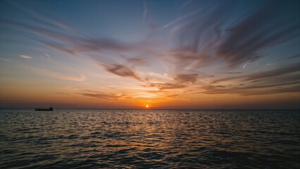 Obraz premium Calm ocean scene at dusk featuring clouds and a vibrant sunset, ideal for a serene background.