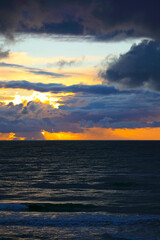 Naklejka premium The dark waters of the Baltic Sea and the clouds at sunset, as seen from Mielno, Poland