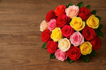 Bright rose bouquet displayed on a rustic wooden background with room for customization