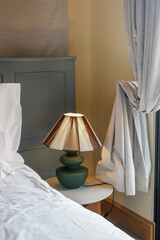 Hotel room scene with bed pillows and lamp on table,White soft pillows on bed,contemporary,Space...