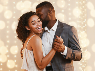 Beautiful loving happy afro couple dancing in modern restaurant. Celebrating St Valentine's Day