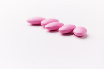 Multivitamin tablets on bright paper background. Close up. Copy space	
