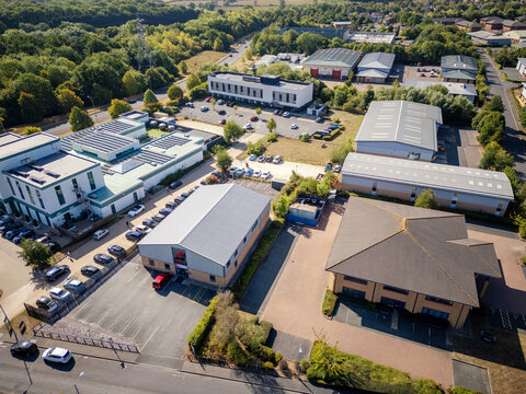 Aerial drone view of industrial warehouses, commercial business park and logistics hub with distribution center, storage units and factory buildings for real estate and investment promotion
