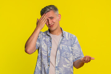 Middle-aged man covering face with hand in classic facepalm gesture, showing deep frustration and...