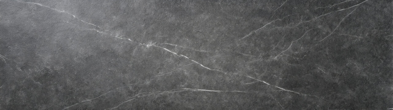 Dark honed soapstone with fine white mineral streaks and subtle textured stone surface
