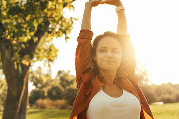 Happy woman  with raised arms enjoying nature and wellbeing
