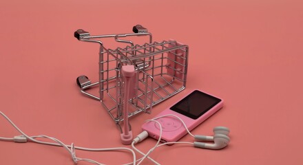 mp3 player with headphones lying near fallen shopping cart 