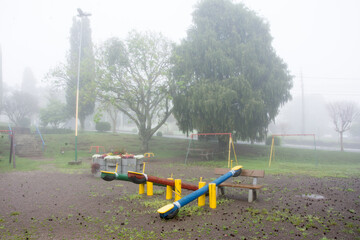 Playground in the park in the foggy weather in autumn