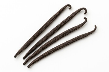 Close-up of dried vanilla plant stems arranged on a white surface, viewed from above