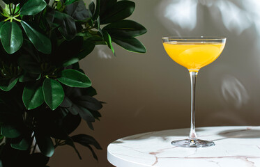 Yellow cocktail drink with whiskey, liqueur and lemon juice. Marble table in elegant bar with...