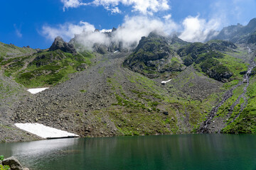 Clouds enveloping the rocky peaks of the Kackarlar mountains reflecting in a glacial lake