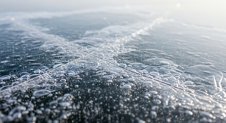 Close-up of clear ice with trapped air bubbles and intricate cracks on a frozen lake surface reflecting sunlight