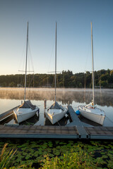 Sailboats in the marina on Lake Baldeneysee in Essen at sunrise. Vertical view